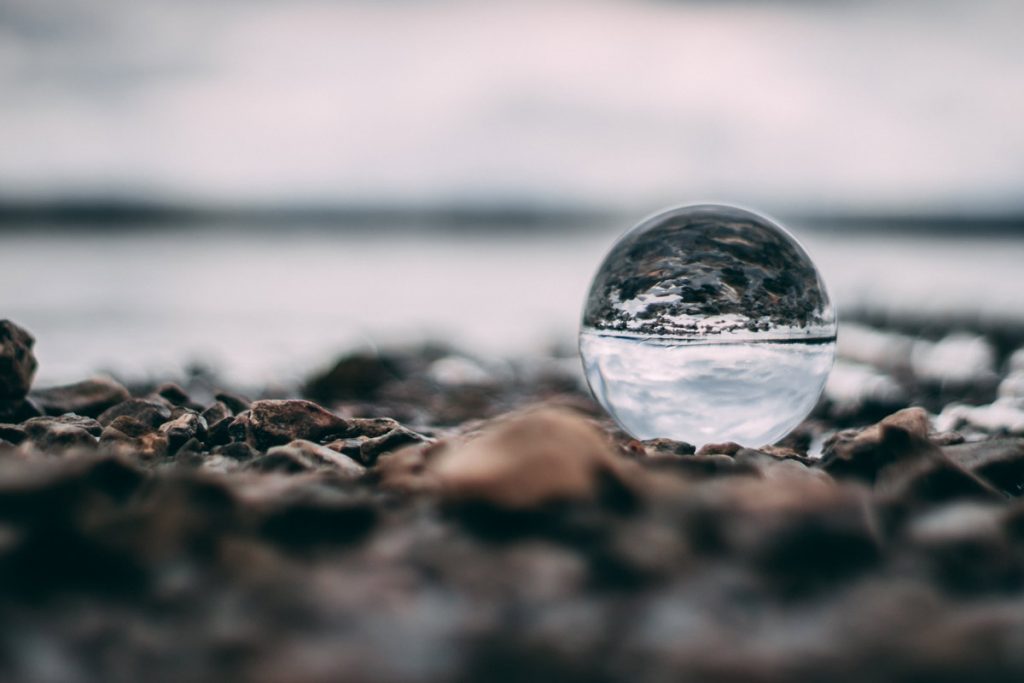 A glass ball on the beach representing the world